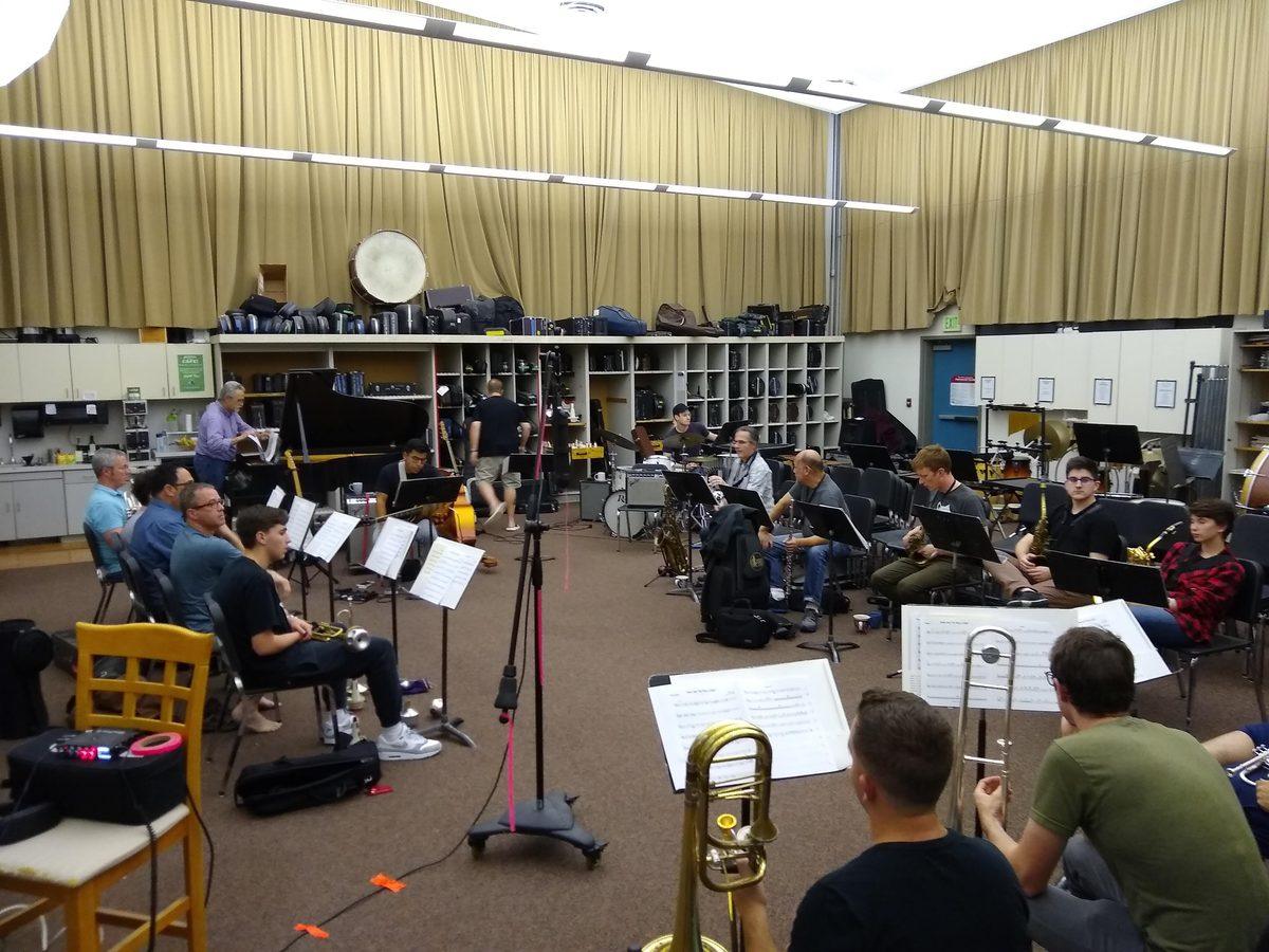A big band rehearsing in a large room, pre-production for the Kyle Athayde Dance Party.